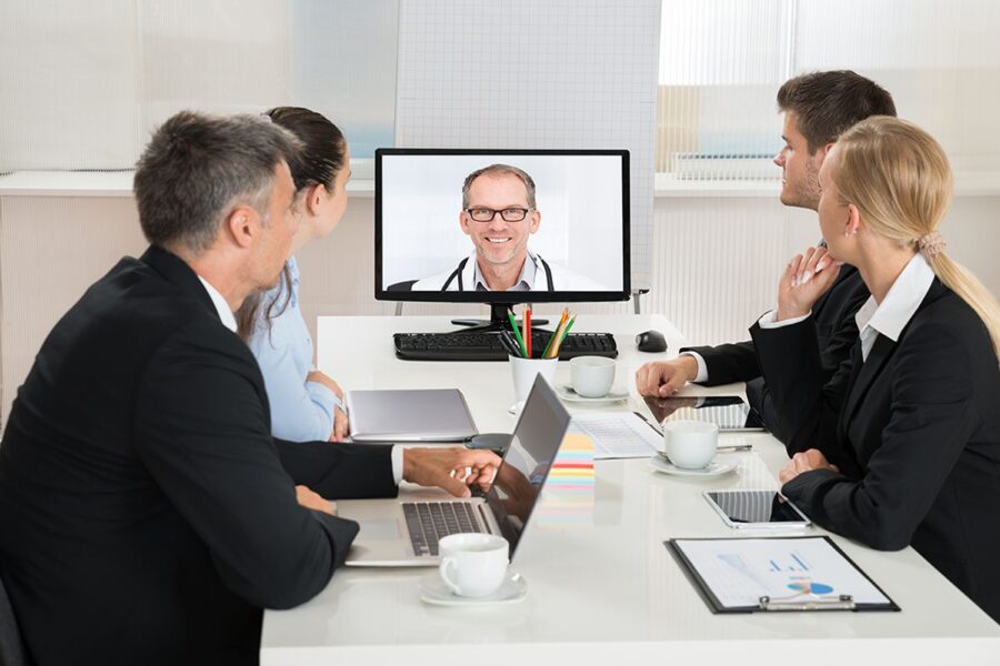 Team of businesspeople video conferencing with a doctor